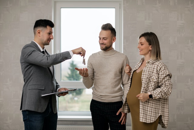 Landlord handing keys to a young couple